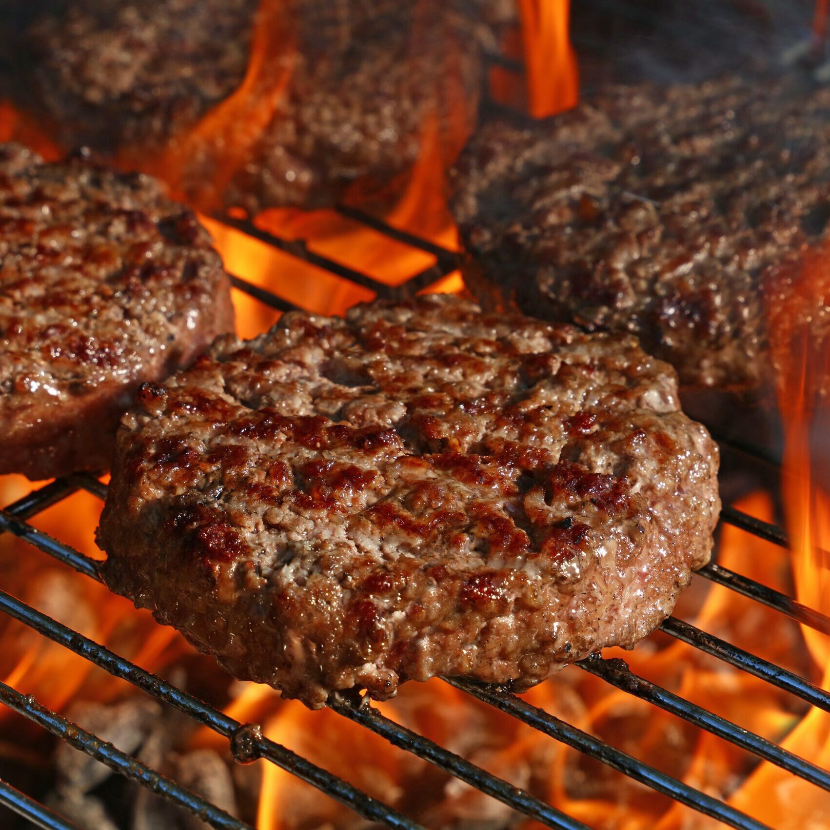 Beef patties on a BBQ grill